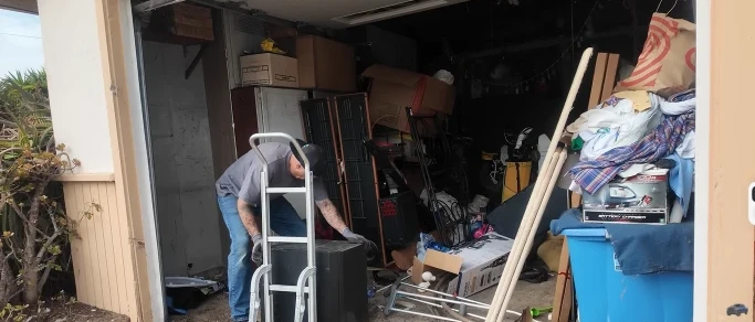 Full garage cleanout junk removal in East Hemet, CA - cluttered garage interior being cleared out